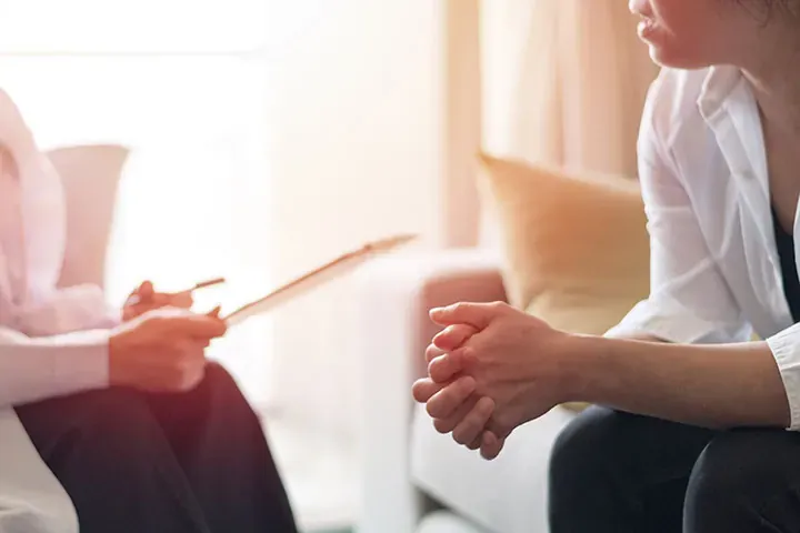 Esthetician taking notes during a lash consultation with a new client
